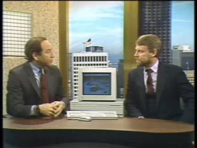 Stewart Cheifet and Gary Kildall on the set of “Computer Chronicles.” On the desk between them is a Macintosh II with a color monitor.