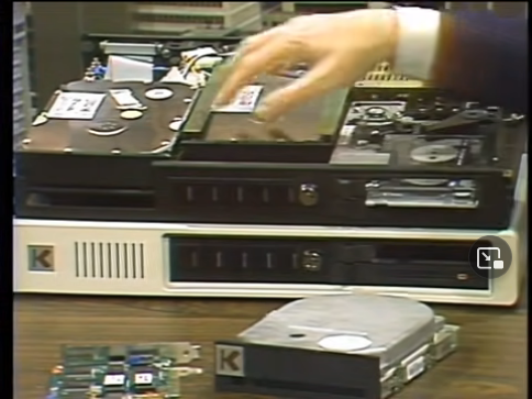 A large rectangular box with the top cover removed. Inside there are two hard disk drives and a tape backup drive.