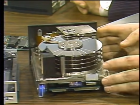 A hard disk drive with the cover removed. You can see four dish platters mounted to the inside of the unit.