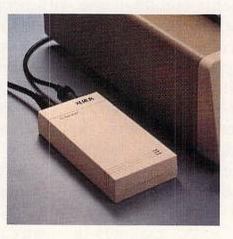 A picture of the Xerox PC Type Right taken from a 1987 magazine ad. The device is a long white box with two black cords plugged into the back.